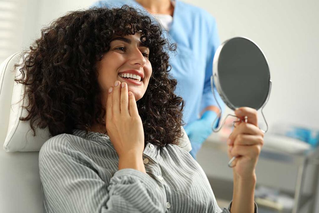 Two teenagers comparing clear aligners and traditional metal braces while seated at a table.